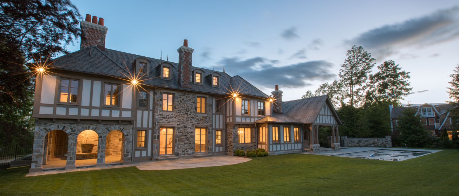 A stunning Greenwich estate mansion is aglow with lights at dusk 